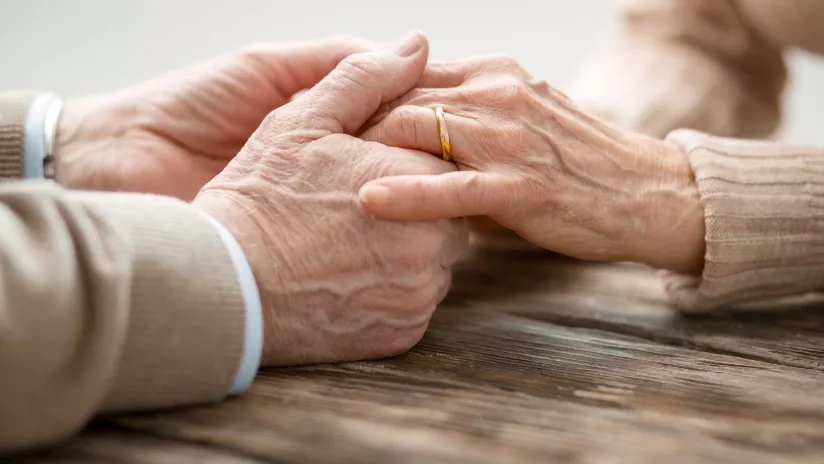 2 personnes âgées se tiennent les mains