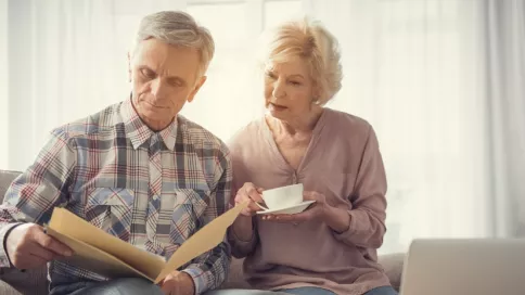 Un couple de personnes âgées regarde des documents