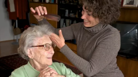 Une coiffeuse s'occupe d'une dame âgée